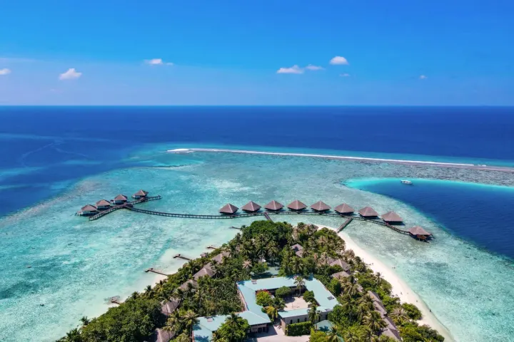 Adaaran Club Rannalhi — панорамный вид сверху на зелёный остров, пляж и коралловый риф