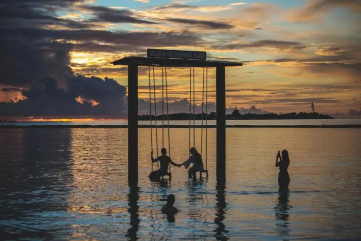 Adaaran Prestige Water Villas, Мальдивы — развлечения Adaaran Prestige Water Villas — качели прямо в океане на фоне красивого заката