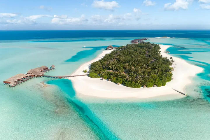 Anantara Dhigu Maldives Resort — панорамный вид сверху на зелёный остров и обширную бирюзовую лагуну