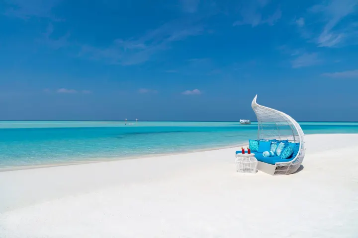 Anantara Dhigu Maldives Resort, Мальдивы — пляж Anantara Dhigu Maldives Resort — шезлонги под зонтиками на широком белоснежном песчаном пляже