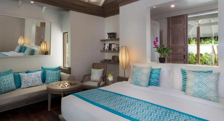 Anantara Dhigu Maldives Resort, Мальдивы — интерьер виллы Anantara Dhigu Maldives Resort — светлая спальня пляжной виллы с отделкой из натурального дерева