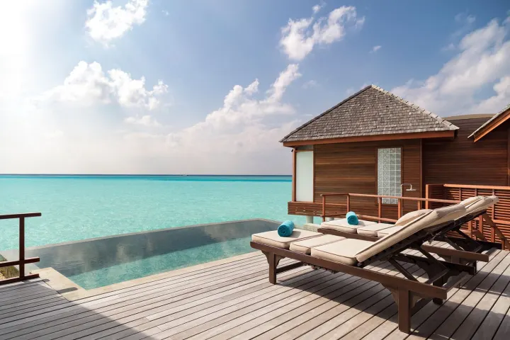 Anantara Dhigu Maldives Resort, Мальдивы — вилла на воде Anantara Dhigu Maldives Resort — солнечная терраса водного люкса с бассейном и шезлонгами