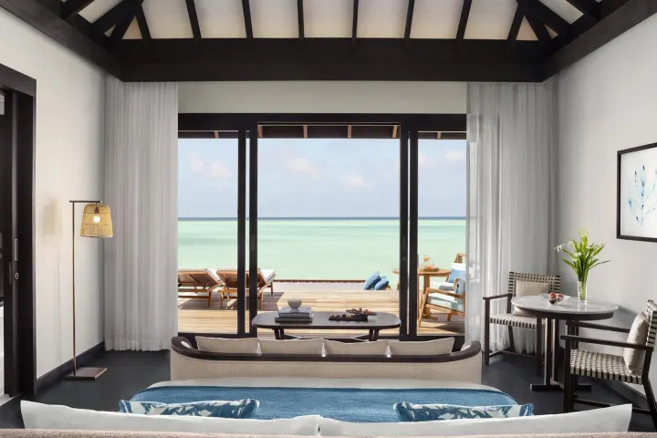 Anantara Veli Maldives Resort — светлая спальня водной виллы с прямым выходом на террасу