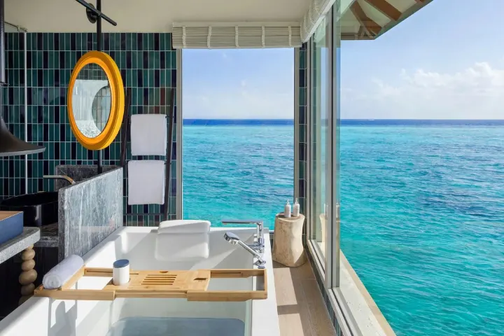 Avani+ Fares Maldives Resort — ванная комната водной резиденции с панорамным окном к океану