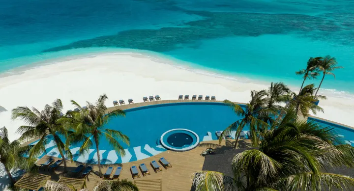Avani+ Fares Maldives Resort — главный бассейн и барная зона у берега океана с высоты