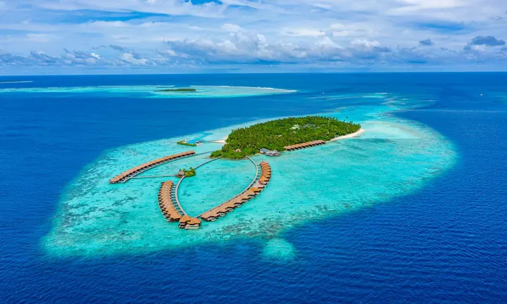 Ayada Maldives — панорамный вид сверху на зелёный остров и кольцо водных вилл