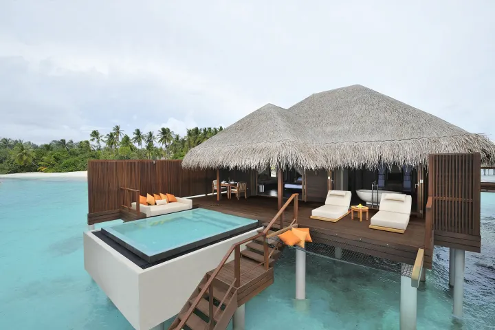 Ayada Maldives, Мальдивы — интерьер виллы Ayada Maldives — спальня водной виллы с восточными акцентами и видом на море