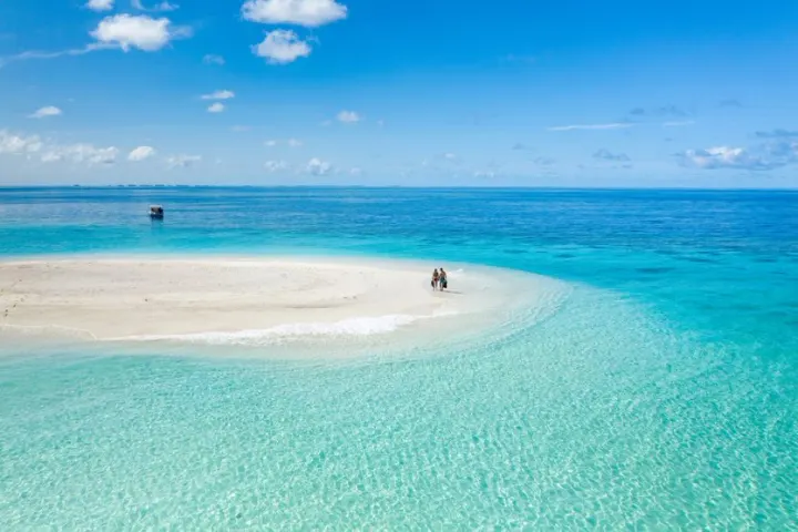 Baglioni Resort Maldives — пара стоит на песчаной косе среди бирюзовой воды