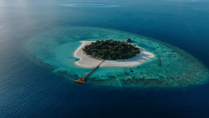Banyan Tree Vabbinfaru, Мальдивы — вид сверху Banyan Tree Vabbinfaru — вид сверху на круглый коралловый остров, белый пляж и риф