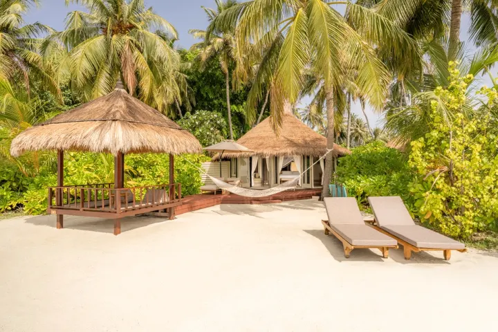 Banyan Tree Vabbinfaru, Мальдивы — вилла на пляже Banyan Tree Vabbinfaru — береговая вилла с конической крышей и выходом к океану