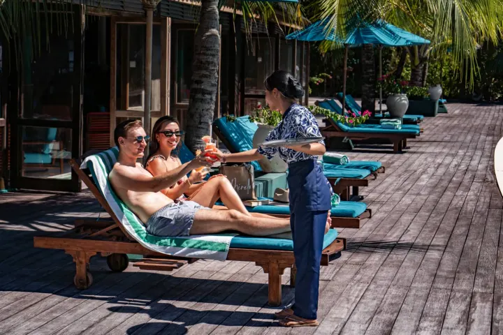 Canareef Resort Maldives, Мальдивы — бассейн Canareef Resort Maldives — бассейн с деревянной палубой и шезлонгами у берега океана