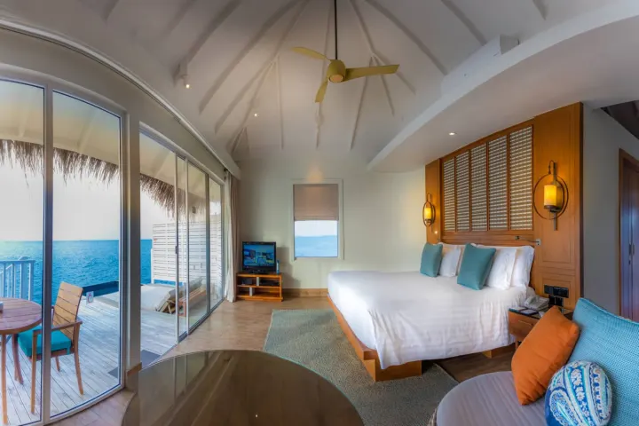 Centara Grand Island Resort & Spa Maldives, Мальдивы — интерьер виллы Centara Grand Island Resort & Spa Maldives — светлая спальня с большой кроватью и панорамными стеклянными дверями