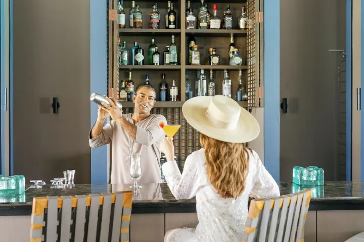 Cheval Blanc Randheli — бармен готовит коктейль за барной стойкой