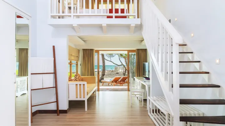Cinnamon Dhonveli Maldives — двухуровневый номер с белой деревянной лестницей
