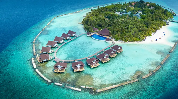 Cinnamon Ellaidhoo Maldives — вид сверху на зеленый остров и водные виллы полукругом