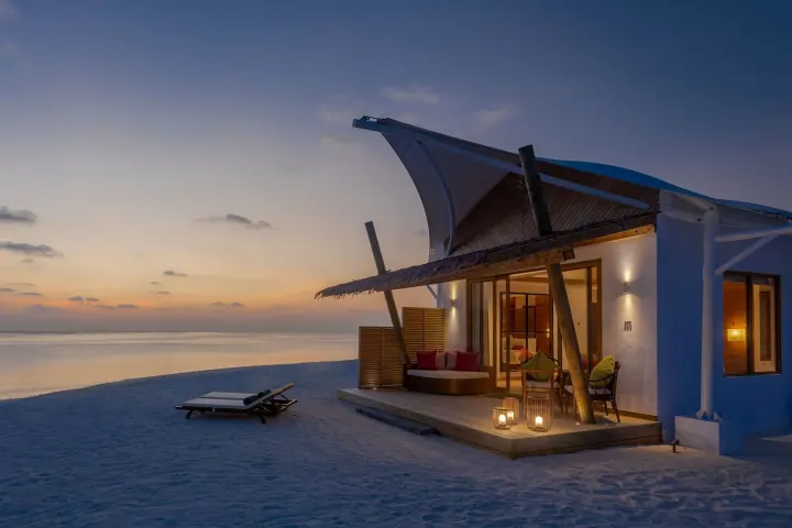 Cinnamon Hakuraa Huraa Maldives, Мальдивы — вилла на пляже Cinnamon Hakuraa Huraa Maldives — вечерняя подсветка береговой виллы на песчаном пляже