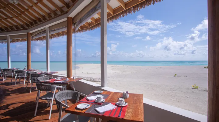 Cinnamon Velifushi Maldives, Мальдивы — ресторан Cinnamon Velifushi Maldives — столики ресторана на открытой террасе с видом на пляж