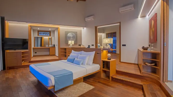 Cinnamon Velifushi Maldives, Мальдивы — интерьер виллы Cinnamon Velifushi Maldives — просторная спальня со светлой кроватью и деревянными полами