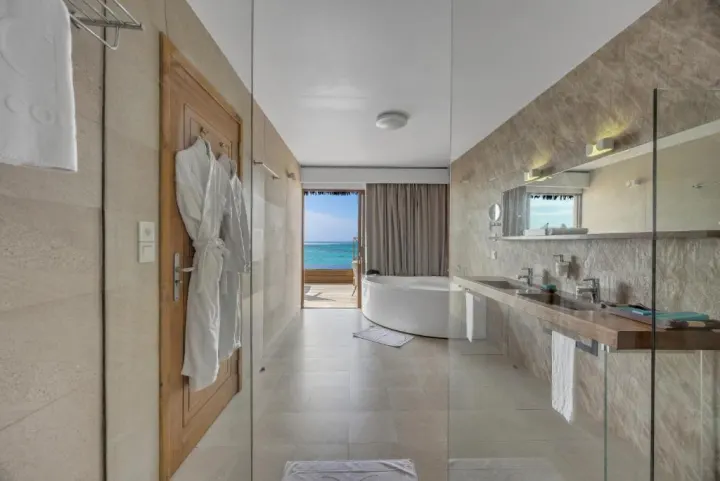 Cocoon Maldives — ванная комната с круглой ванной и видом на океан