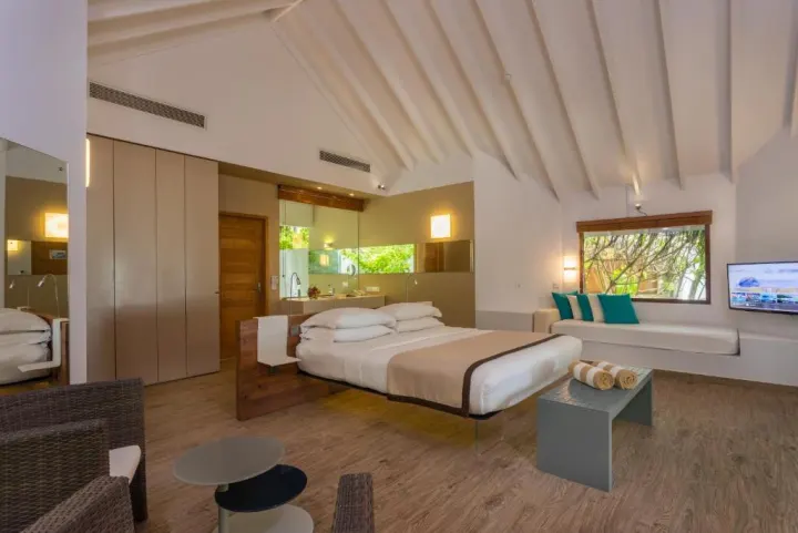 Cocoon Maldives — светлая спальня с двуспальной кроватью