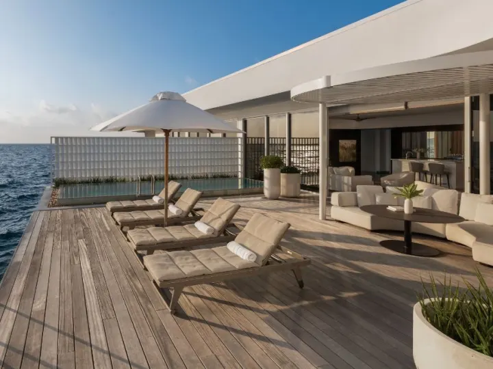 Conrad Maldives Rangali Island — просторная терраса водной виллы с шезлонгами