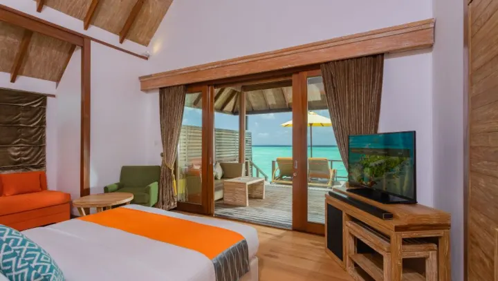 Dhigufaru Island Resort, Мальдивы — интерьер виллы Dhigufaru Island Resort — просторная спальня с яркими оранжевыми акцентами