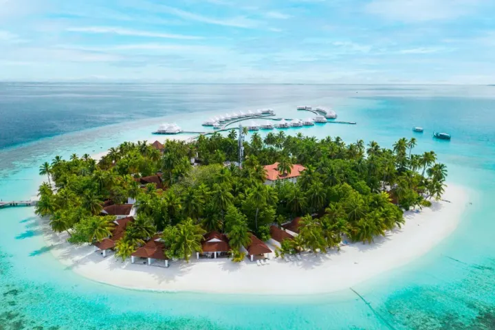 Diamonds Athuruga Maldives, Мальдивы — интерьер виллы Diamonds Athuruga Maldives — светлая спальня водной виллы в белоснежных тонах с кроватью под балдахином