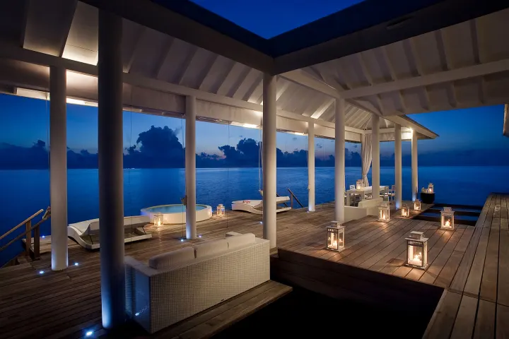 Diamonds Athuruga Maldives, Мальдивы — вилла на воде Diamonds Athuruga Maldives — деревянная палуба водной виллы с шезлонгами и прямым спуском в океан