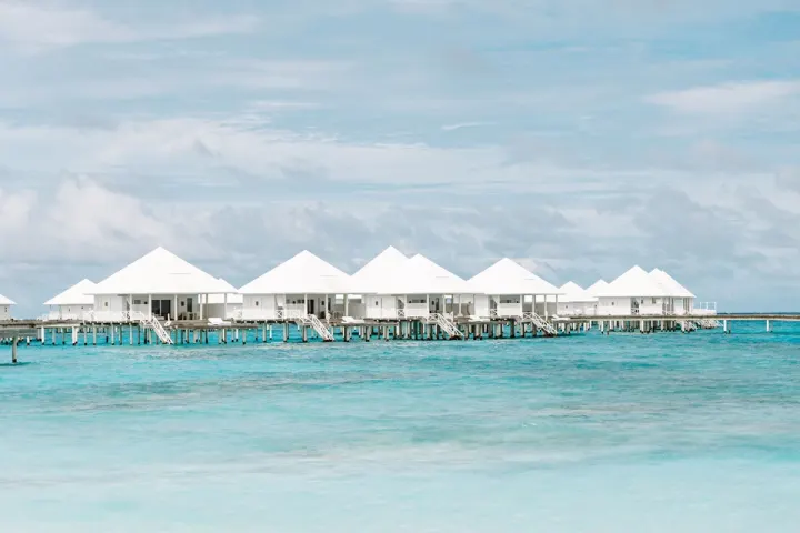 Diamonds Thudufushi Maldives, Мальдивы — интерьер виллы Diamonds Thudufushi Maldives — светлый интерьер водной виллы с белоснежной мебелью и выходом на террасу