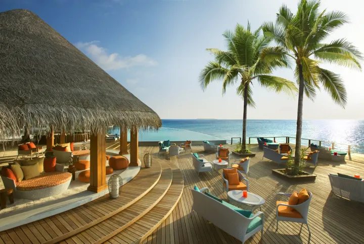 Dusit Thani Maldives — уютная лаунж-зона бара у океана
