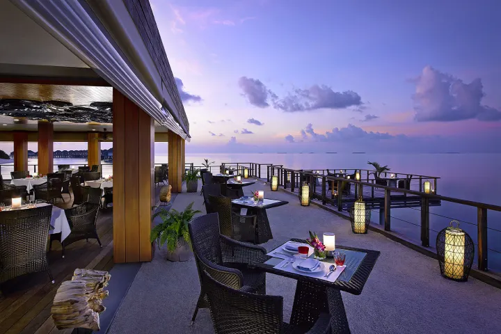 Dusit Thani Maldives — терраса ресторана на закате