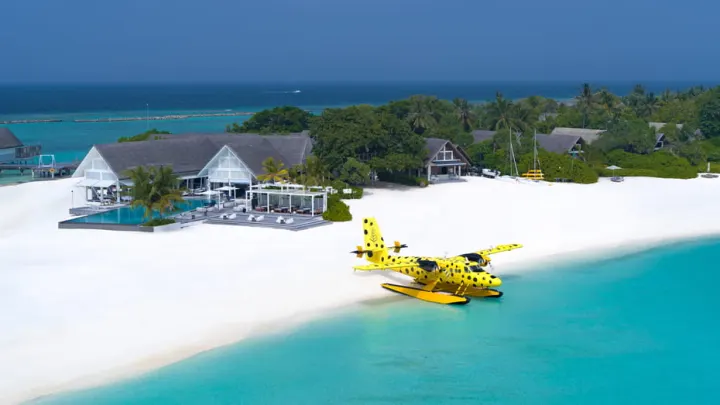 Four Seasons Resort Maldives at Landaa Giraavaru — желтый гидросамолет на воде у острова