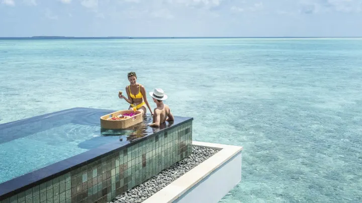 Four Seasons Resort Maldives at Landaa Giraavaru — пара наслаждается завтраком в бассейне