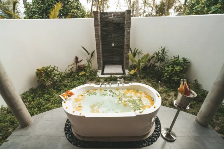 Fushifaru Maldives — открытая ванна с цветами в тропическом саду