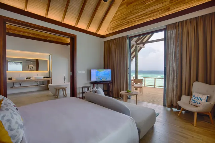 Fushifaru Maldives — светлая спальня с кроватью и видом на океан