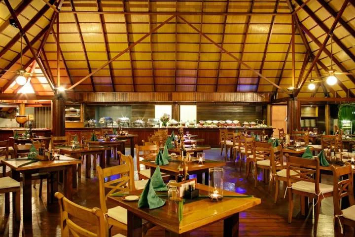 Gangehi Island Resort & Spa — панорамный ресторан над водой с видом на лагуну и закат