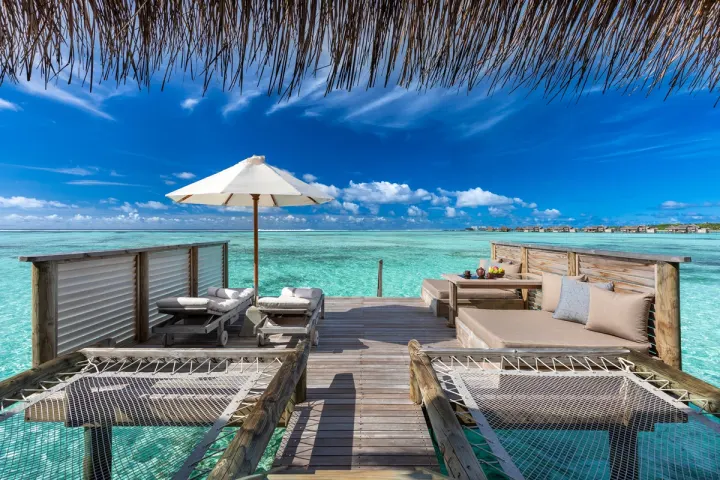 Gili Lankanfushi, Мальдивы — вилла на воде Gili Lankanfushi — деревянная терраса водной виллы с шезлонгами