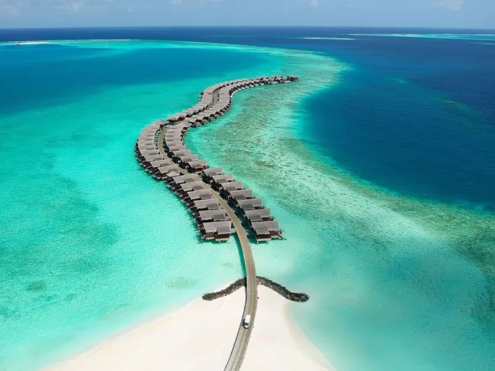 Grand Park Kodhipparu Maldives — панорамный вид с воздуха на остров и изгибающуюся ветку водных вилл