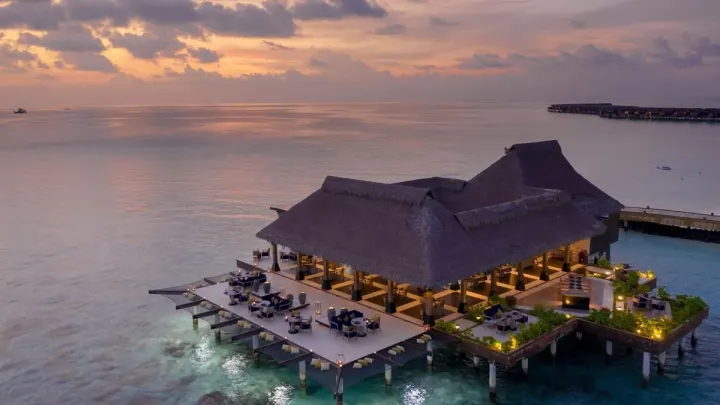 Grand Park Kodhipparu Maldives, Мальдивы — ресторан Grand Park Kodhipparu Maldives — павильон фирменного ресторана над водой с вечерней подсветкой