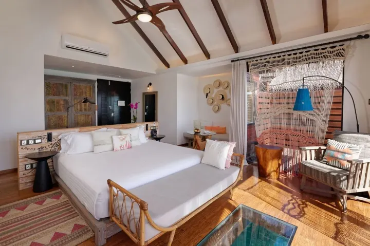 Grand Park Kodhipparu Maldives, Мальдивы — интерьер виллы Grand Park Kodhipparu Maldives — светлая спальня водной виллы с панорамным видом на Индийский океан