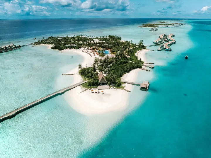 Hard Rock Hotel Maldives — панорамный вид с воздуха на остров, лагуну и водные виллы курорта