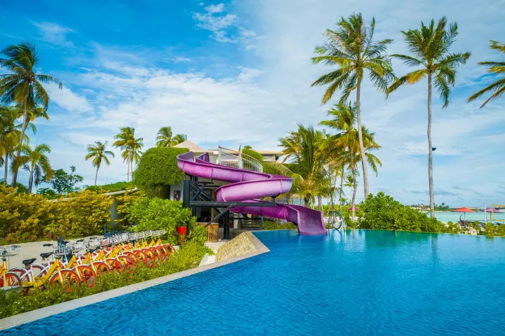 Hard Rock Hotel Maldives — главный бассейн с водной горкой и баром на берегу океана
