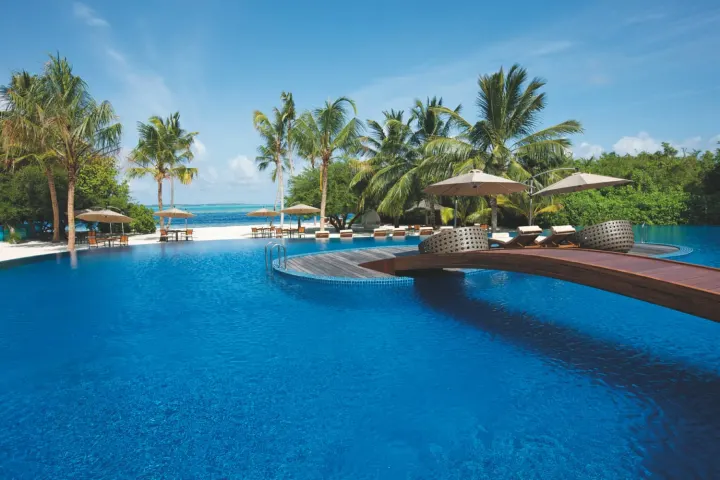 Hideaway Beach Resort & Spa, Мальдивы — бассейн Hideaway Beach Resort & Spa — главный панорамный бассейн с шезлонгами у кромки океана