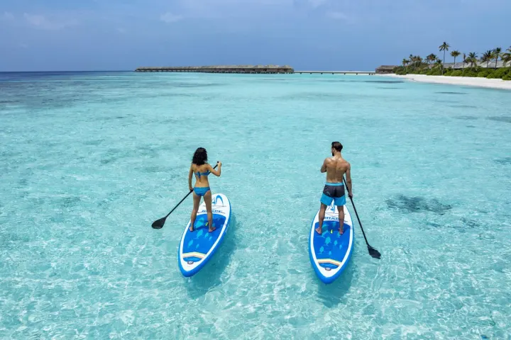 Hurawalhi Island Resort — гости катаются на сапбордах в лагуне