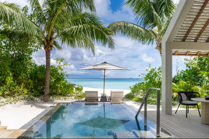 JW Marriott Kaafu Atoll Island Resort — песчаный пляж и зона отдыха у берега с видом на лазурную лагуну