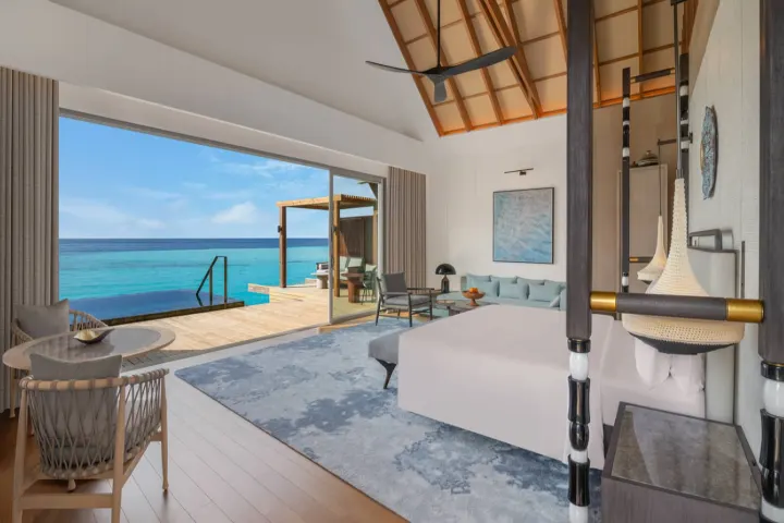 JW Marriott Kaafu Atoll Island Resort — элегантная спальня водной виллы с панорамным остеклением и террасой