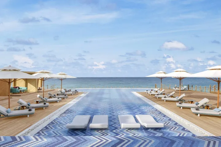 JW Marriott Maldives Resort & Spa — деревянная палуба водной виллы с большим бассейном и видом на океан