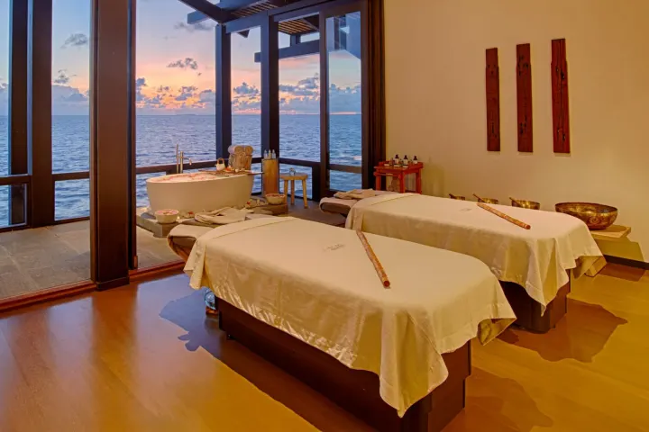 Kudadoo Maldives Private Island — спа-кабинет с массажными столами и ванной у окна