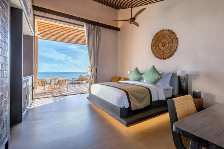 Kudadoo Maldives Private Island — просторная спальня с панорамным видом на океан