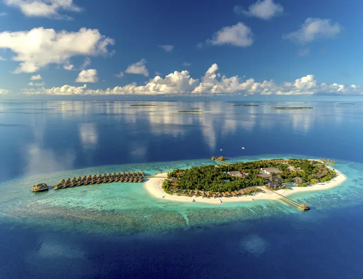 Kudafushi Resort & Spa, Мальдивы — вид сверху Kudafushi Resort & Spa — панорама зеленого острова и бирюзовой лагуны с высоты